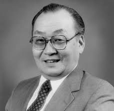 Black and white formal portrait of Dawon Kahng, smiling